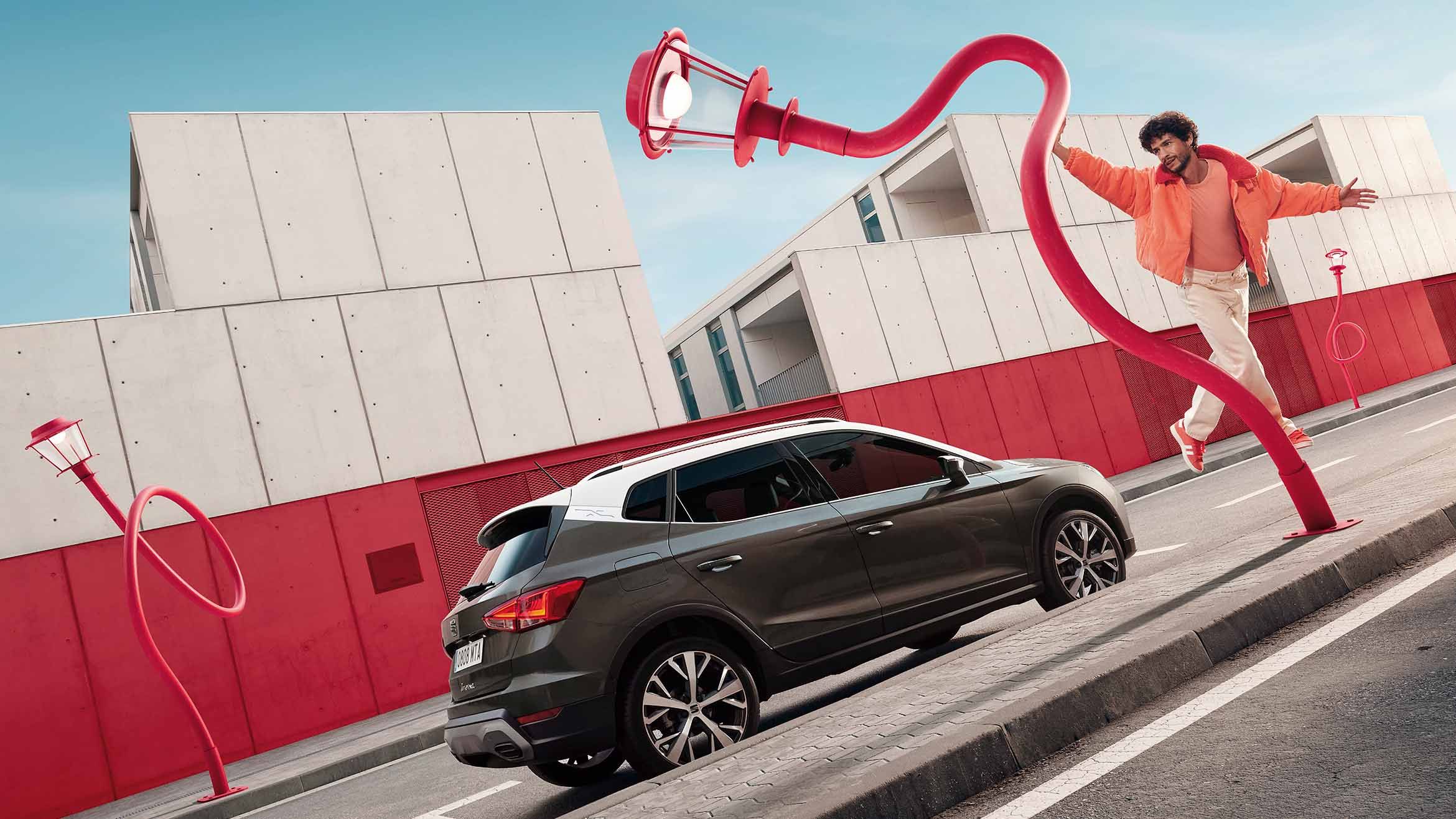 woman in red dress charging red seat leon 2024 fr e-hybrid car